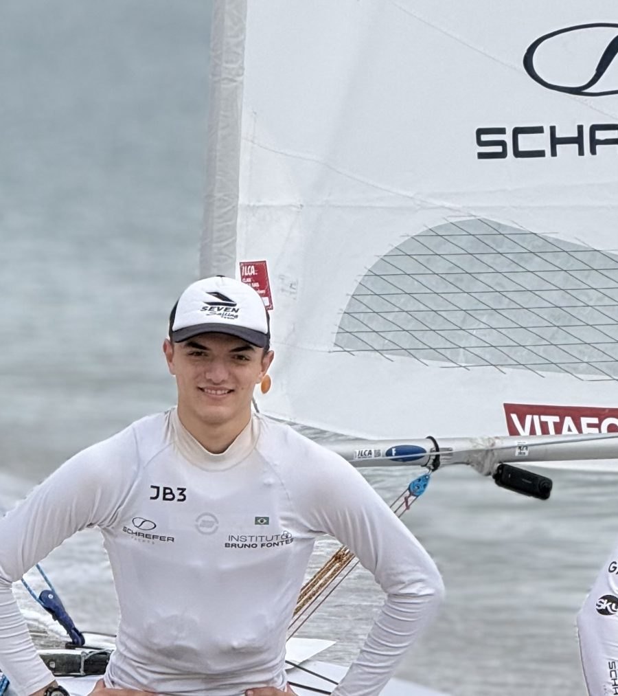 Davi Neves com o uniforme do Instituto Bruno Fontes, JB3 e Schaefer, em frente ao veleiro