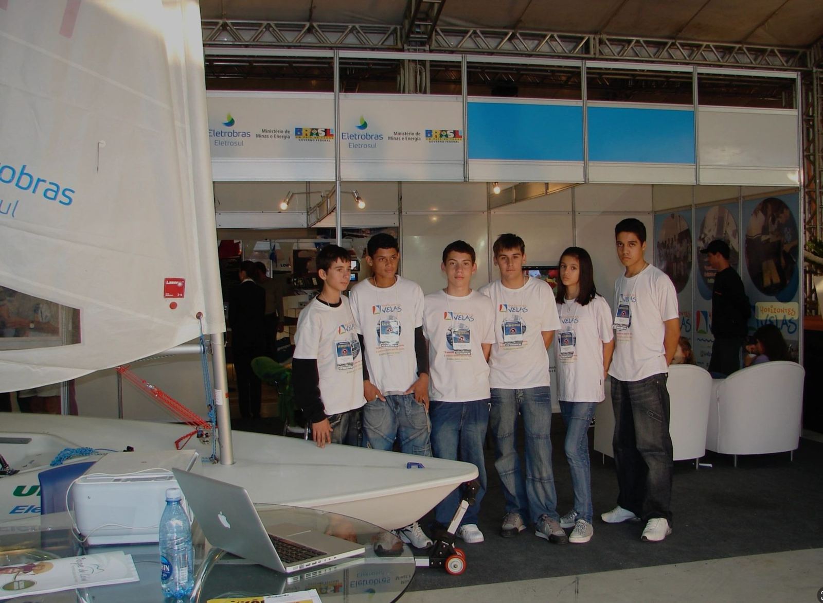 Jovens do Projeto Horizontes Velas em evento com veleiro, uniformizados